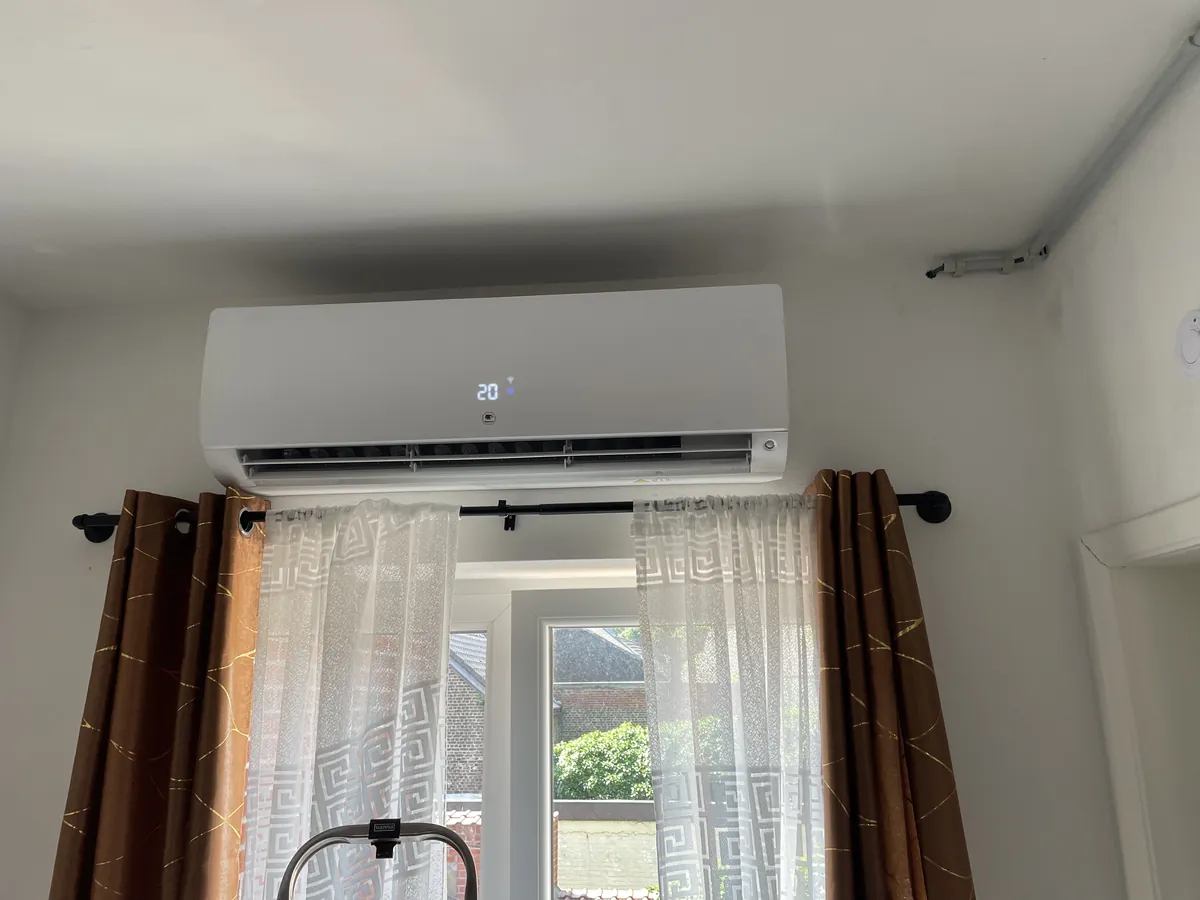 Climatisation réversible murale installée au-dessus d’une fenêtre